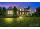 Charming home with stone accents, inviting front porch, manicured lawn, and professionally landscaped front yard at 2501 Christenbury Hall Nw Ct, Concord, NC 28027