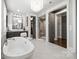 Luxurious main bathroom featuring a soaking tub, a walk-in shower, and dual vanity sinks at 2501 Christenbury Hall Nw Ct, Concord, NC 28027