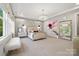 Beautiful main bedroom featuring a decorative bed, chandelier, and views of trees through the windows at 2501 Christenbury Hall Nw Ct, Concord, NC 28027