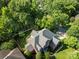 Overhead view of the brick home with mature trees and a well-manicured lawn at 2504 Fallbrook Pl, Concord, NC 28027