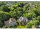 An aerial image showcasing a brick home with landscaped grounds surrounded by trees at 2504 Fallbrook Pl, Concord, NC 28027