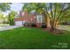 Brick home with attached garage, white picket fence, and lush green backyard at 2504 Fallbrook Pl, Concord, NC 28027