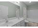 Bright bathroom featuring a double sink vanity, tiled floors, and a shower-tub combo at 2504 Fallbrook Pl, Concord, NC 28027