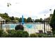 A large community pool with blue umbrellas, lounge chairs, and a surrounding fence for safety and privacy at 2504 Fallbrook Pl, Concord, NC 28027