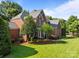Attractive brick home showcases lush green lawn and meticulous landscaping, perfect for outdoor enjoyment at 2504 Fallbrook Pl, Concord, NC 28027