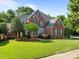 A brick two-story home with lush landscaping and a well-maintained lawn at 2504 Fallbrook Pl, Concord, NC 28027