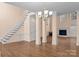 Bright living room featuring hardwood floors, fireplace, staircase, and abundant natural light at 2504 Fallbrook Pl, Concord, NC 28027