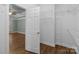 Open walk-in closet with wire shelving located just off a bedroom with hardwood floors and a ceiling fan at 2504 Fallbrook Pl, Concord, NC 28027