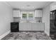 Well-lit kitchen features white cabinets, granite counters, black appliances and dark grey tile flooring at 2519 2Nd Sw Ave, Hickory, NC 28602
