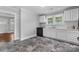 Well-lit kitchen features white cabinets, granite counters, black appliances and dark grey tile flooring at 2519 2Nd Sw Ave, Hickory, NC 28602