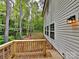 Side view of home with wood deck, siding, large windows, and surrounded by tall trees, blending comfort with nature at 2612 Cold Springs Rd, Concord, NC 28025