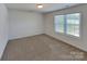 A bright bedroom features neutral carpet, white walls, and a sunlit window, creating a calming and inviting space at 2612 Cold Springs Rd, Concord, NC 28025