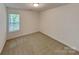 A bright bedroom offers neutral carpet, white walls, and a window with green views, perfect for relaxation at 2612 Cold Springs Rd, Concord, NC 28025