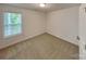 Cozy bedroom features neutral carpet, white walls, and a bright window, creating a simple and comfortable retreat at 2612 Cold Springs Rd, Concord, NC 28025