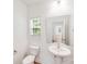 Modern powder room features a pedestal sink, toilet, and a large mirror with natural light at 2612 Cold Springs Rd, Concord, NC 28025