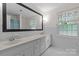 Bright bathroom featuring a double vanity with storage, a large mirror, and a window at 2917 Rustic Ln, Charlotte, NC 28210