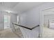 Upstairs hallway featuring neutral paint, white railings, and access to bedrooms and bathrooms at 2917 Rustic Ln, Charlotte, NC 28210
