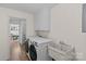 Well-lit laundry room featuring modern washer/dryer, storage, and tile sink at 2917 Rustic Ln, Charlotte, NC 28210