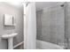 Bathroom features a tiled shower-tub combo and a sleek pedestal sink at 307 Elm St, Belmont, NC 28012