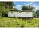 Side view of a single-story house with white siding and overgrown grass at 307 Elm St, Belmont, NC 28012