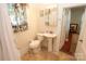 A cozy bathroom features a pedestal sink, patterned tile flooring, and a decorative window curtain at 309 S Greene St, Wadesboro, NC 28170
