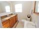 Cozy bathroom with wood cabinets, a white sink and toilet, and wainscoting halfway up the wall at 309 S Greene St, Wadesboro, NC 28170