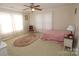 Bright bedroom featuring a ceiling fan, neutral walls, and natural light filtering through sheer curtains at 309 S Greene St, Wadesboro, NC 28170