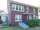 Rear exterior view of a brick home with white-framed windows, and visible basement access at 309 S Greene St, Wadesboro, NC 28170