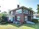 Back of a brick home with a sunroom, well-kept lawn and AC unit at 309 S Greene St, Wadesboro, NC 28170