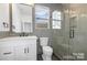 Modern bathroom with gray tiling, glass shower, white vanity, and natural light at 3119 Shenandoah Ave, Charlotte, NC 28205