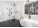 Sleek bathroom with soaking tub, walk-in shower, and dark tile floors at 3119 Shenandoah Ave, Charlotte, NC 28205