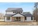 Rear view of home with a gabled roof, black trim, a covered porch, and natural wood porch posts at 3119 Shenandoah Ave, Charlotte, NC 28205