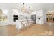 Modern kitchen with a large center island, pendant lighting, stainless steel appliances, and white cabinetry at 3119 Shenandoah Ave, Charlotte, NC 28205