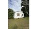 Side view of home featuring white siding, traditional shutters, grass, and air conditioning unit at 322 Buffalo St, Shelby, NC 28150