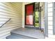Covered front porch with a red screen door and coat rack at 3221 5Th Street Nw Ct, Hickory, NC 28601