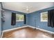 Cozy bedroom with ceiling fan, hardwood floors, and two windows with black curtains at 3230 Kingsfield Rd, Rock Hill, SC 29732