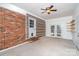 Large bedroom with exposed brick wall, French doors, shelving, and a ceiling fan at 3230 Kingsfield Rd, Rock Hill, SC 29732