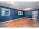 Living room with striking blue walls, wood flooring and a large window showcasing a green, tree filled view at 3230 Kingsfield Rd, Rock Hill, SC 29732