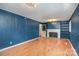 Spacious living room featuring built-in bookshelves, fireplace, hardwood floors, and blue paneled walls at 3230 Kingsfield Rd, Rock Hill, SC 29732