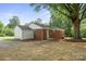 Rear exterior of brick home with a detached garage and tree coverage at 346 Fieldstone Cir, Statesville, NC 28677