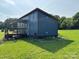 Home exterior featuring a small deck and a natural setting on a sunny day at 490 County Line Rd, Stony Point, NC 28678