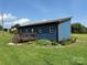 Quaint home with a manicured lawn, garden beds, and a cozy front porch with steps at 490 County Line Rd, Stony Point, NC 28678