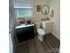 Bathroom featuring dual vanities, a toilet and a window letting in natural light at 512 S Gray St, Gastonia, NC 28052