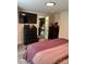 Well-lit bedroom featuring a television, dresser, and a glimpse into the kitchen at 512 S Gray St, Gastonia, NC 28052