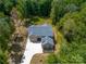 Aerial view of a beautifully landscaped home with a long driveway and lush trees at 5217 Waterfall Ct, Gastonia, NC 28056