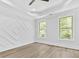 Bright bedroom with tray ceiling, wood floors, accent wall, and large windows offering wooded views at 5217 Waterfall Ct, Gastonia, NC 28056