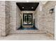 Elegant entryway showcasing a double door with a covered porch and stylish brick accents at 5217 Waterfall Ct, Gastonia, NC 28056