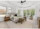 Large primary bedroom with a king bed, seating area, and windows offering bright, wooded views at 5217 Waterfall Ct, Gastonia, NC 28056
