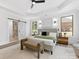 Spacious primary bedroom with a king bed, bench, barn door, and windows with wooded views at 5217 Waterfall Ct, Gastonia, NC 28056