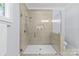 Bathroom walk-in shower features glass door, stone flooring, and tiled walls at 5638 Timber Ln, Charlotte, NC 28270